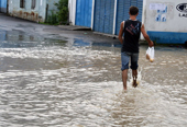 A young man makes his way across a flooded street in Tbilisi yesterday