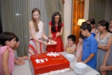 Honor Vitae staff members cut cake with children