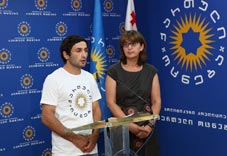 Georgian Olympic wrestler, Betkil Shukvani speaks at the podium wearing a Kartuli Ostneba shirt.