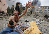 Zaza Razmadze holds the body of his brother Zura after a bombardment in Gori, 80 km from Tbilisi, August 9, 2008. A Russian warplane dropped a bomb on an apartment block in the Georgian town of Gori, killing at least 5 people